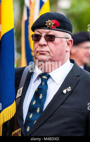 England, Ramsgate. Remembrance sunday. Elderly ex-serviceman with sunglasses on, wearing beret with poppy on the front. Standing to attention. Stock Photo