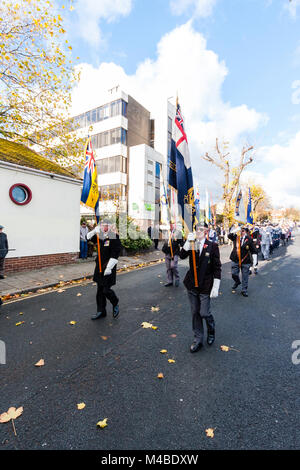 England, Ramsgate. Remembrance sunday. View along parade, elderly men holding flags marching in middle of road, various other behind. Stock Photo