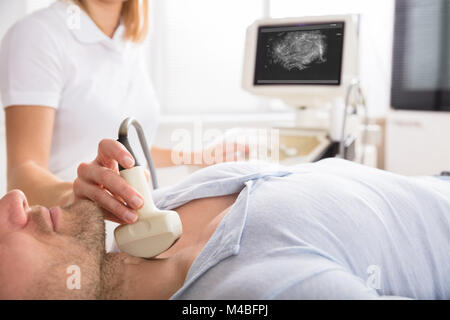 Male Patient Undergoing Ultrasound Of Thyroid Gland In Examination Room Stock Photo