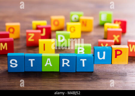 Start Up Text On Multi Colored Cubes On Wooden Table Stock Photo