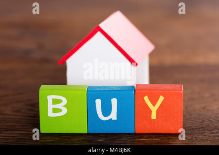 Small House Model With Word Buy On Multi Colored Blocks Stock Photo