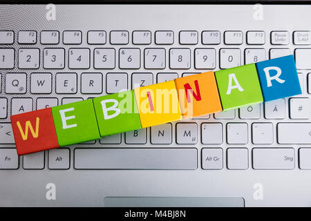 Webinar Text On Colorful Blocks Over Laptop Keyboard Stock Photo