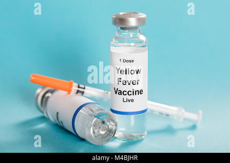 Yellow Fever Vaccine Bottle With Syringe Over Turquoise Background Stock Photo