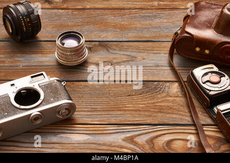 Vintage cameras and lenses on wooden background Stock Photo