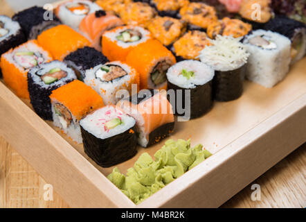 Big sushi and roll set with wasabi on wooden tray Stock Photo