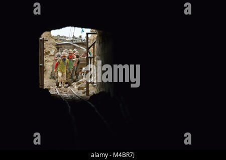 Miners push an ore cart outside a mine in Potosi, Bolivia. The mine produces silver and other metals. Stock Photo