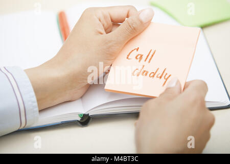 Call daddy text on adhesive note Stock Photo
