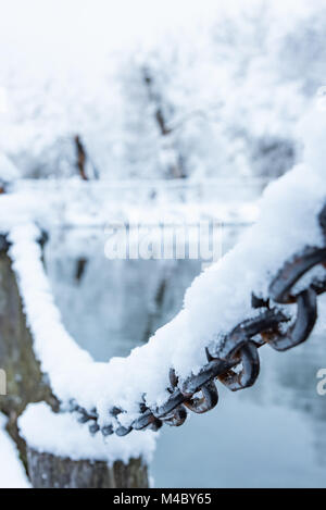 old rusty iron chain on a frost covered with snow Stock Photo