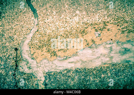 Rough cement texture with pebbles and patched cracks Stock Photo