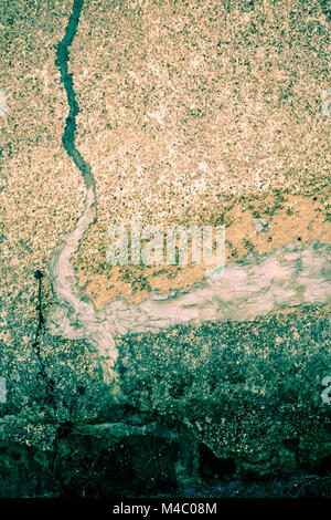 Rough cement texture with pebbles and patched cracks Stock Photo