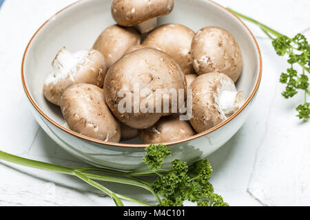 Brown mushrooms in a bowl with parsley - Close up