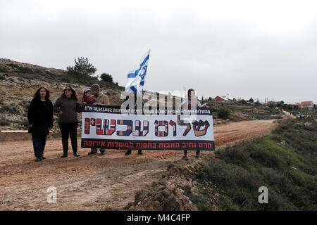 Nativ Ha'avot, Israel. 15th Feb, 2018. Activists from the right wing Zionist organization Im Tirtzu holds a sign reading “Peace Now, Destruction of Netiv Ha’avot, with support of European governments” n a counter protest to leftists from Peace Now movement who arrived to Nativ Ha'avot following Israeli government attempts to postpone the removal of some of the houses in the Jewish outpost despite the Supreme Court ruling. Credit: Eddie Gerald/Alamy Live News