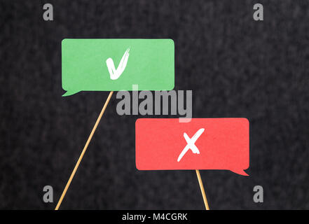 Right and wrong. Disagreement, argument and fight concept. Different opinions, morals and values. V and X sign on cardboard speech bubbles. Stock Photo