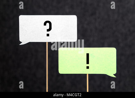 Question and answer. Interview, education and communication concept. Question and exclamation mark on cardboard speech bubble or balloon on wooden sti Stock Photo