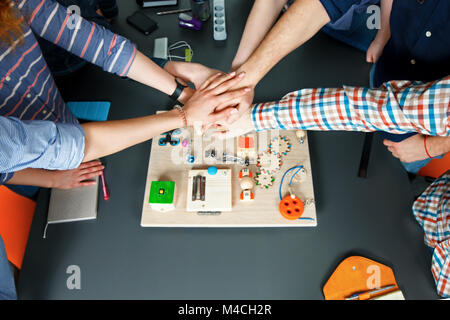 Close up top view of young people putting their hands together. Stock Photo