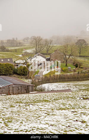 A snowy dales farm with snow shoers behind Stock Photo