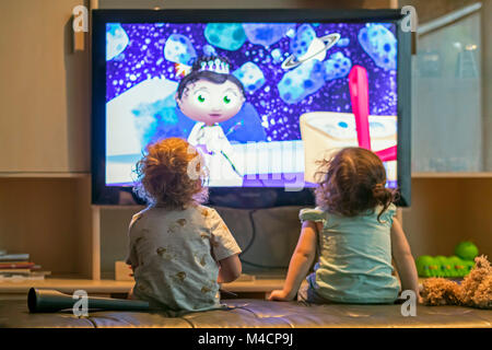 Pre-school children watch cartoons on television. Stock Photo