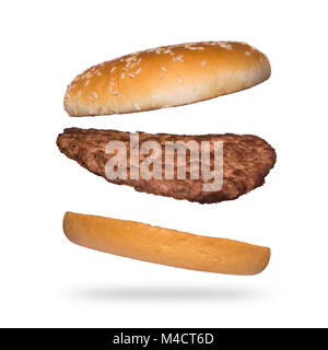 Flying burger isolated on white background. Ingredients for burger. Bun with sesame and beef cutlets. Stock Photo