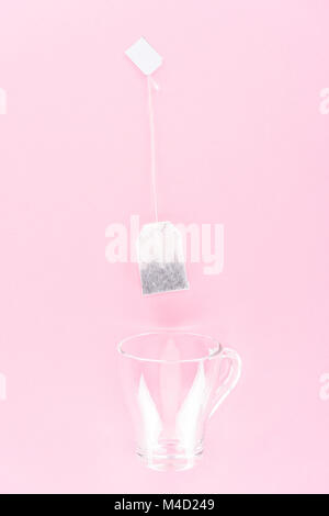 top view of one tea bag and empty glass cup isolated on pink Stock Photo