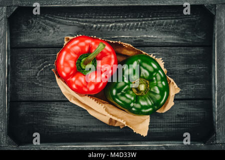 top view of red and green bell peppers in shopping paper bag Stock Photo