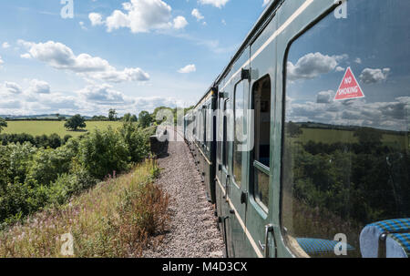 View from railway carriage window along the length of a train on The Gloucestershire and Warwickshire Steam Railway. Gloucestershire, England. UK. Stock Photo