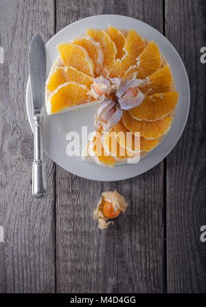 Cheesecake decorated with oranges and physalis. Stock Photo