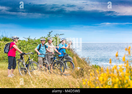 Urlauber auf einer Biketour am Meer Stock Photo