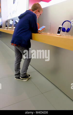 A boy looking at a new iphone at an apple store in Utah. Stock Photo