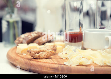 Different delicious cheeses on wooden round board Stock Photo