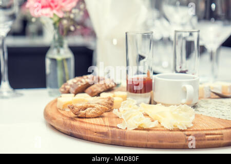 Different delicious cheeses on wooden round board Stock Photo