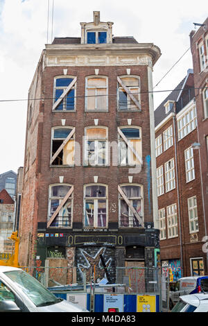 Multi unit building,in Amsterdam, undergoing renovation. Graffiti on street level. Apartment construction site in the city. Stock Photo