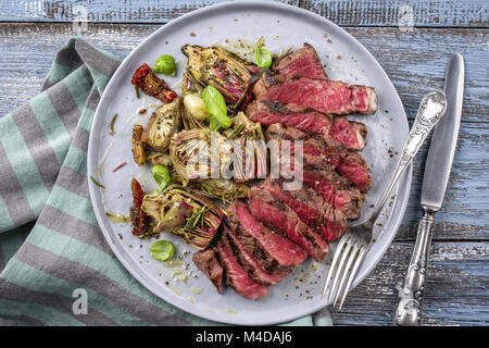 Barbecue Tagliata with Artichokes on Plate Stock Photo