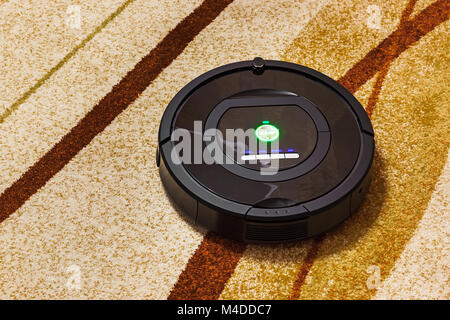 Robotic vacuum cleaner on carpet Stock Photo