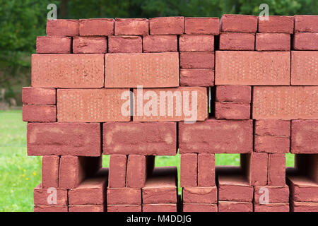 Stack of piled red bricks outside Stock Photo