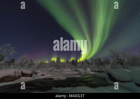 Northern lights above moonlit landscape, Lapland, Sweden Stock Photo