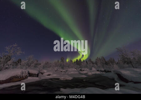 Northern lights above moonlit landscape, Lapland, Sweden Stock Photo