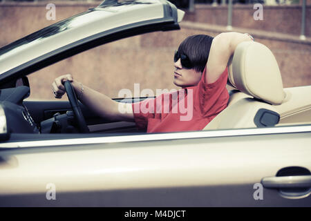Young man driving a convertible car Stock Photo