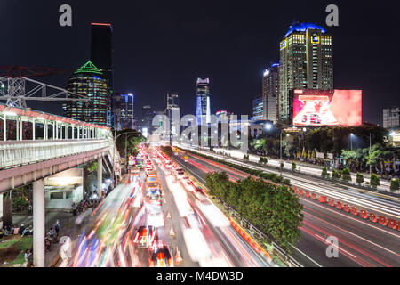 Heavy traffic captured with blurred motion on Gatot Subroto highway in the heart of Jakarta business district in Indonesia capital city at night in So Stock Photo