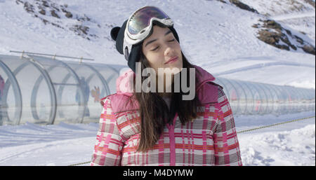 Young woman relaxing on ski slope in winter Stock Photo