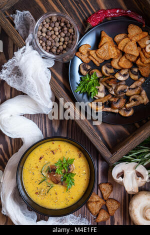 Pea soup with mushrooms in black plate. Stock Photo