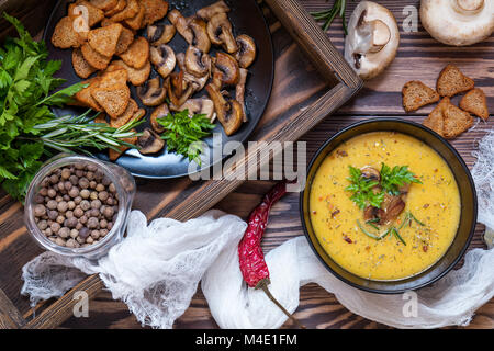 Pea soup with mushrooms in black plate. Stock Photo