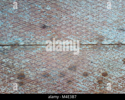 Abstract grunge texture of a metallic surface of blue color with traces of rust and relief diamonds throughout the square. Stock Photo