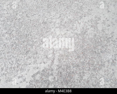 Abstract grunge texture is a gentle gray color with indeterminate spots from the impregnations of small stones in the urban asphalt. Stock Photo