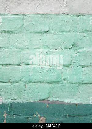 Abstract texture of brick wall covered with stripes of paint white, salad and dark green color, vertical frame. Stock Photo