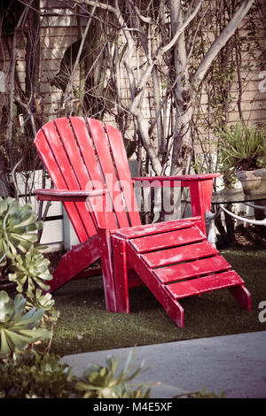 Red wooden vintage beach chair in the garden Stock Photo