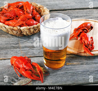 Tasty boiled crayfishes and beer on old table Stock Photo