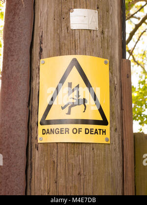 yellow electric danger sign on post Stock Photo