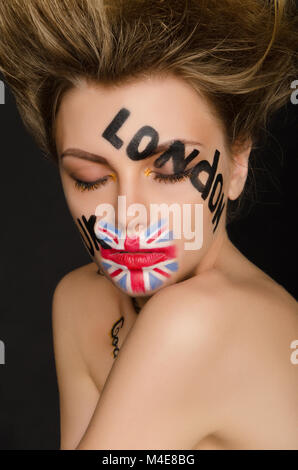 Inscriptions and flag of england on young woman's face Stock Photo