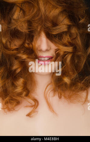 Beautiful curly red hair on the face of woman Stock Photo