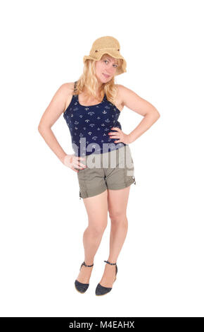 Woman standing in shorts and straw hat. Stock Photo